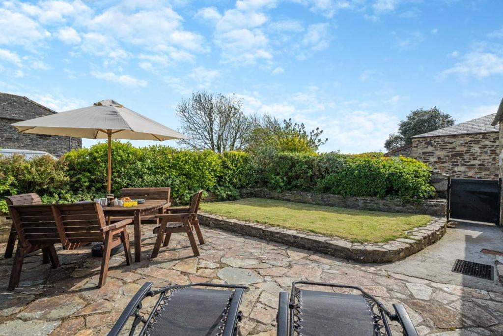 a patio with a table and chairs and an umbrella at 3 Bed in St. Merryn oc-m29320 in Saint Merryn
