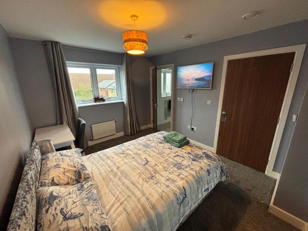 a bedroom with a bed and a television in it at Hawksbill way in Peterborough