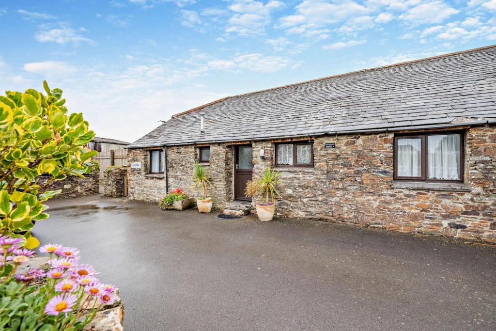 a brick house with potted plants in front of it at 2 Bed in Padstow oc-w3658 in Saint Merryn