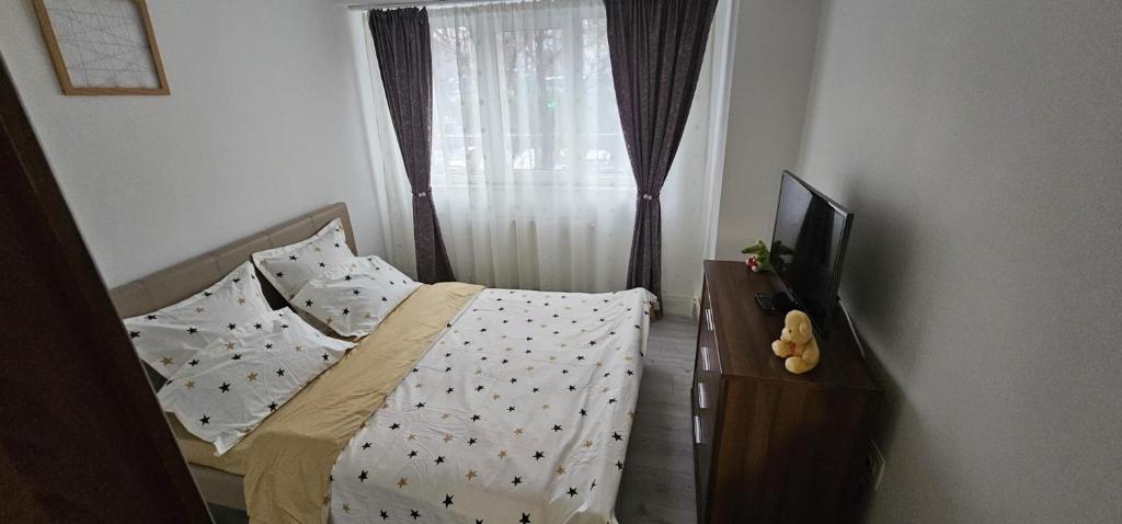 a bedroom with a bed and a dresser with a television at Apartament Daniela in Râmnicu Vâlcea