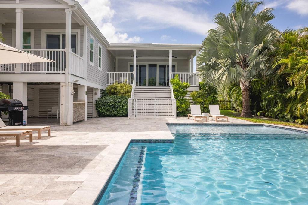 a house with a swimming pool in front of a house at Seagate House -Waterfront w Dock in Key West