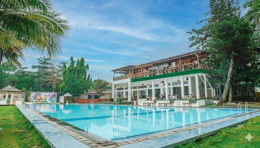 a resort with a swimming pool and a building at La Plage Beach Club in Tjikakaka