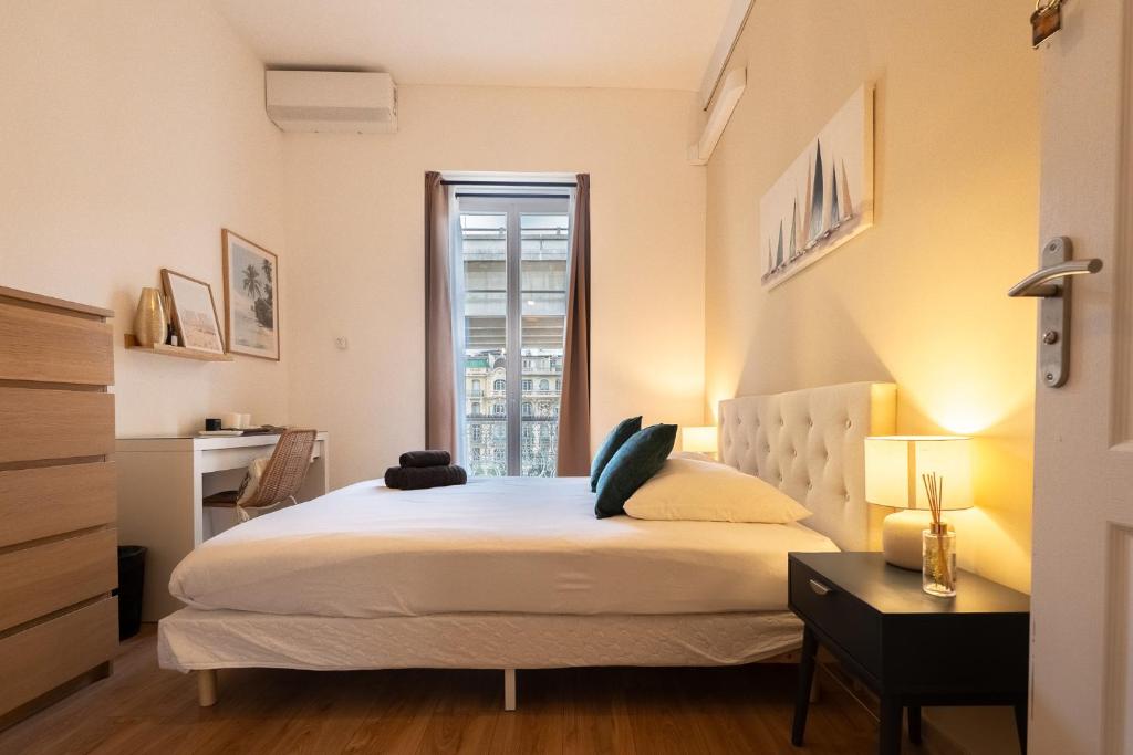 a bedroom with a large white bed with a window at Chambre 2 La Calada in Nice