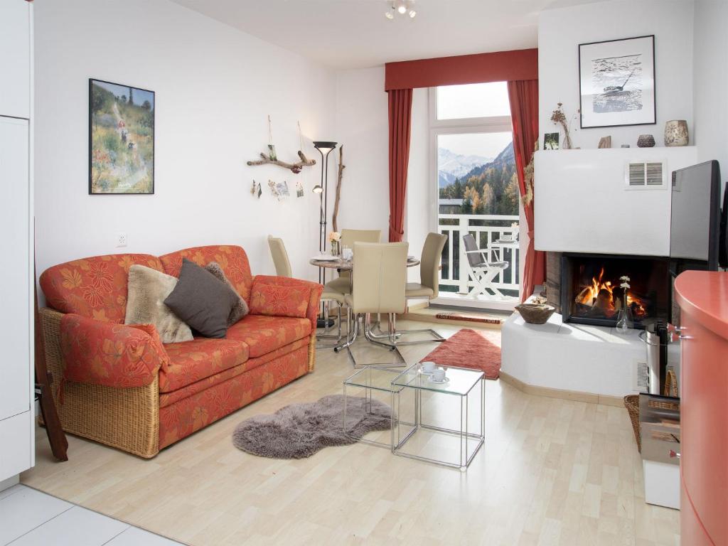 a living room with a red couch and a fireplace at Apartment Alpes et Lac 28 by Interhome in Champex