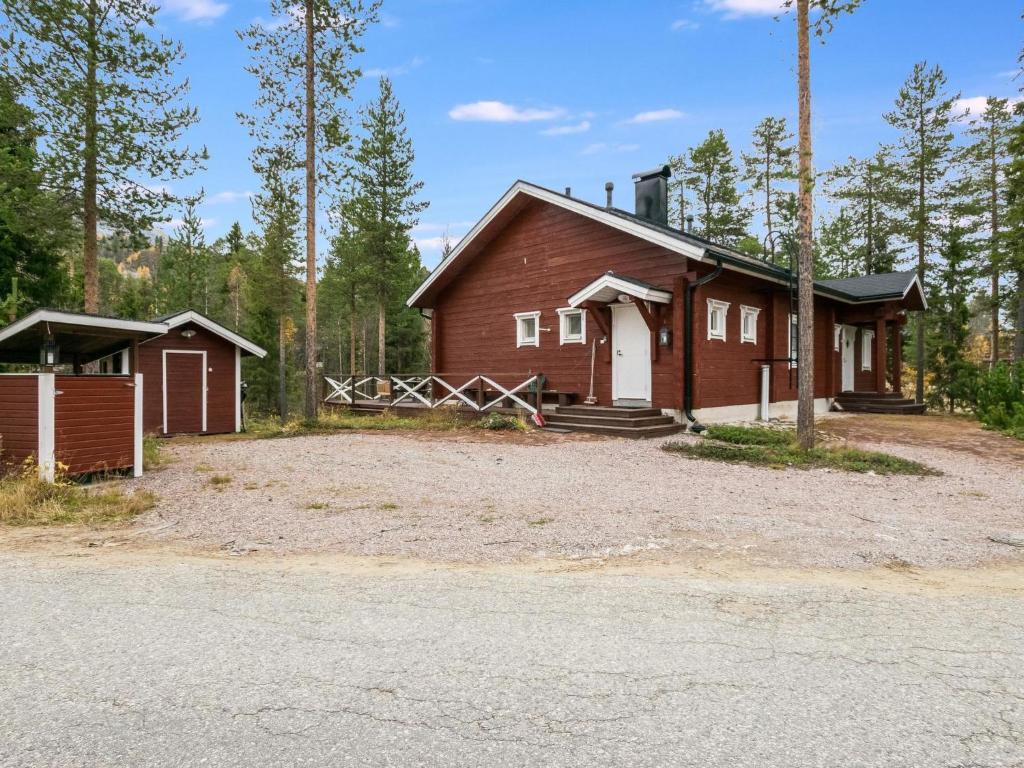 a large red house with two buildings in the woods at Holiday Home Isokuru 3 by Interhome in Pyhätunturi