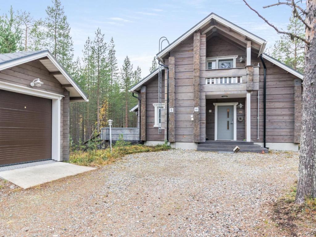 a wooden house with a garage and a driveway at Holiday Home Otso by Interhome in Pyhätunturi