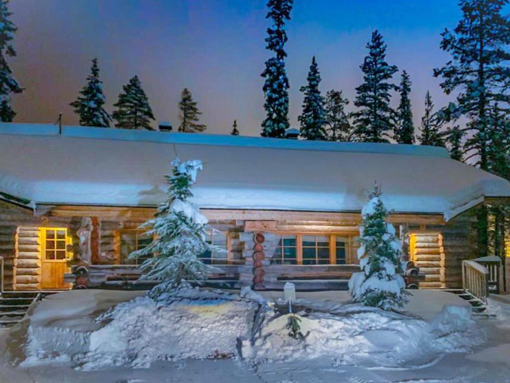 a log cabin in the snow with snow covered trees at Holiday Home Joikupirtti b by Interhome in Pyhätunturi