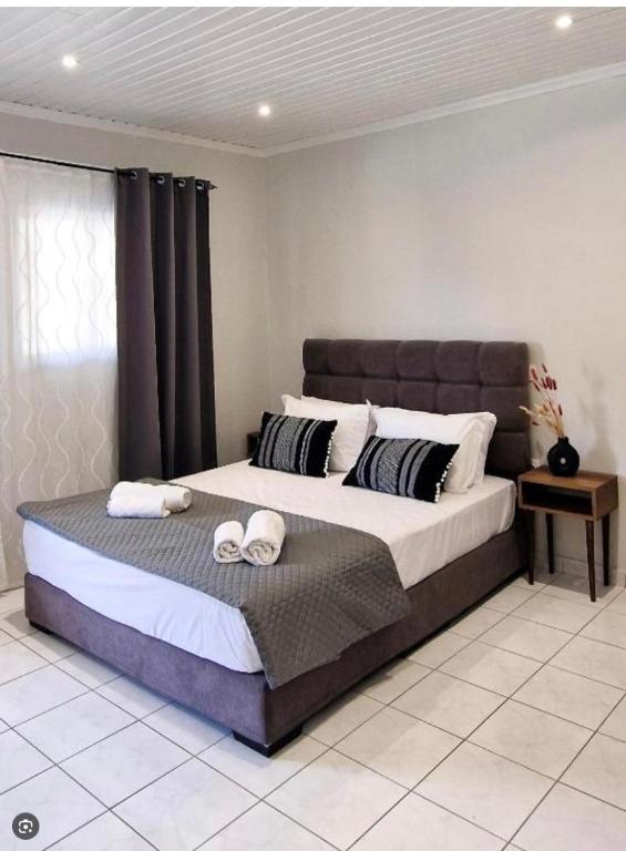 a bedroom with a large bed with two towels on it at Αγριελια Apartments in Platy