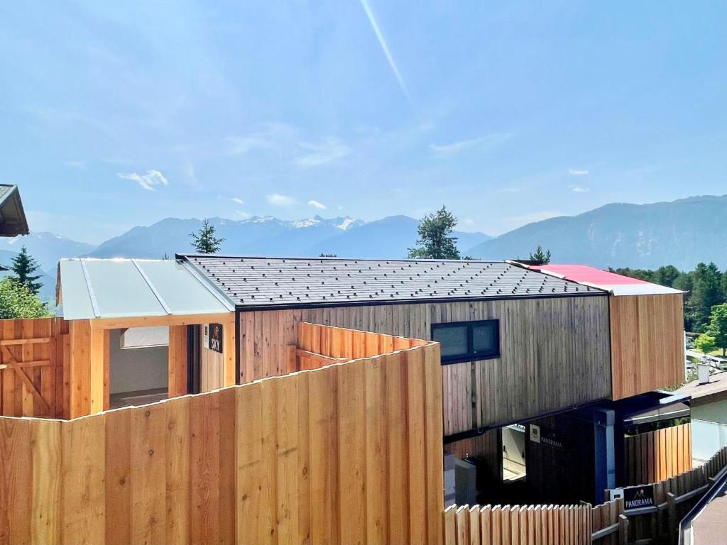 a house with a fence and mountains in the background at Holiday Home Sky-Chalet by Interhome in Imst