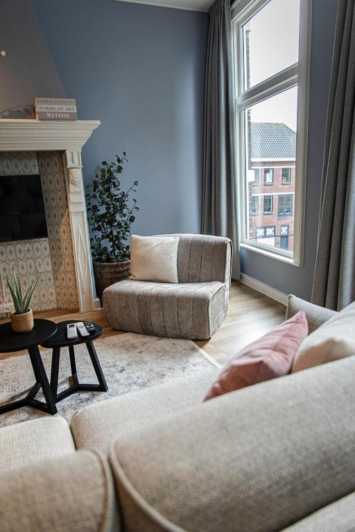 a living room with two couches and a fireplace at Hartje Centrum in Zwolle