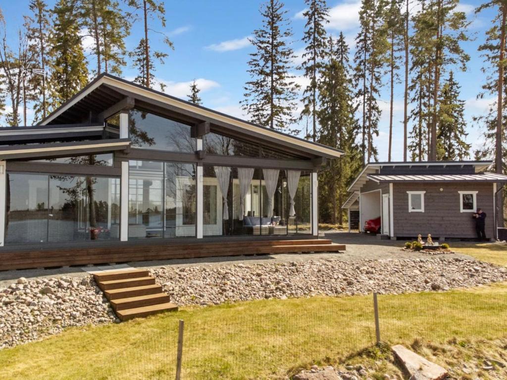 a home with glass walls and a house at Holiday Home Metsäpirtti by Interhome in Keuruu