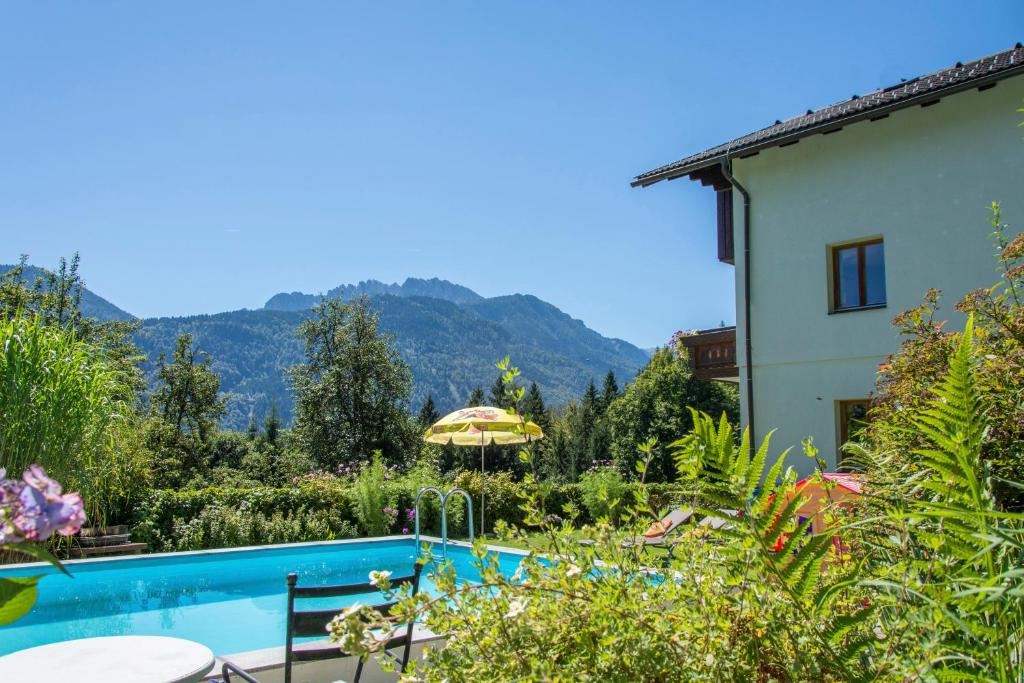 a villa with a swimming pool and mountains in the background at Ferienhaus Waldhof in Hermagor