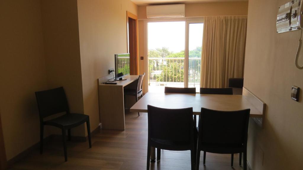 a living room with a table and chairs and a television at Apartaments Players in Malgrat de Mar