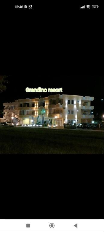 a building with a sign on top of it at night at Grandino rooms & apartments in Ulcinj