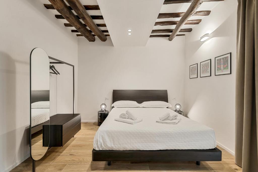 a white bedroom with a bed and a mirror at Il Fiore del Prione in La Spezia