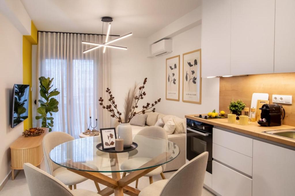 a kitchen and living room with a glass table and chairs at Ophelia's - Luxury Apartment in Volos