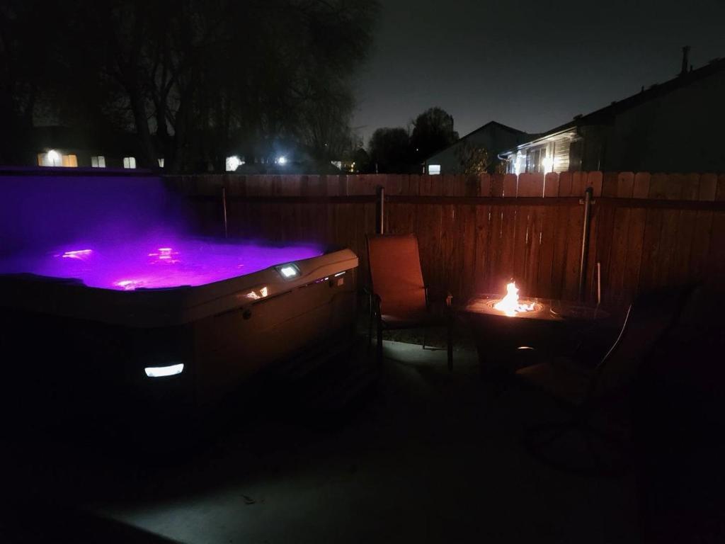 a backyard with a hot tub and a table with a candle at Haven Oasis in Nampa