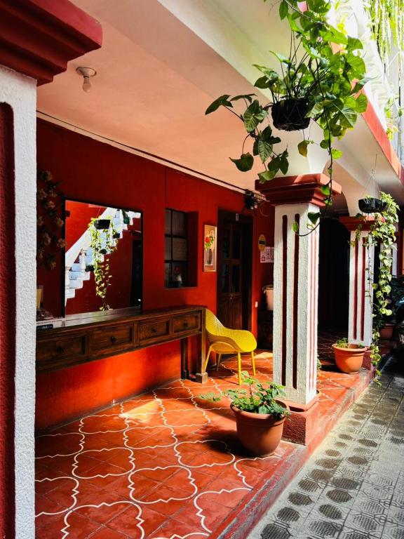 a lobby with a yellow chair and red walls at Cristales de Antigua La Calzada in Antigua Guatemala