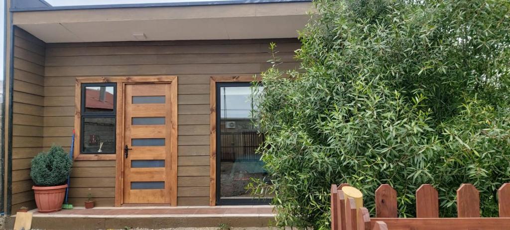 a house with a wooden door and a fence at Cabaña Roquin Patagonia in Chile Chico
