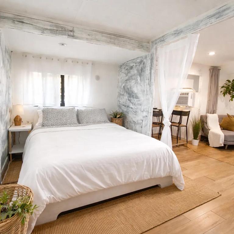 a bedroom with a white bed and a living room at Social Distanсing Approved Nature Getaway! in Naples