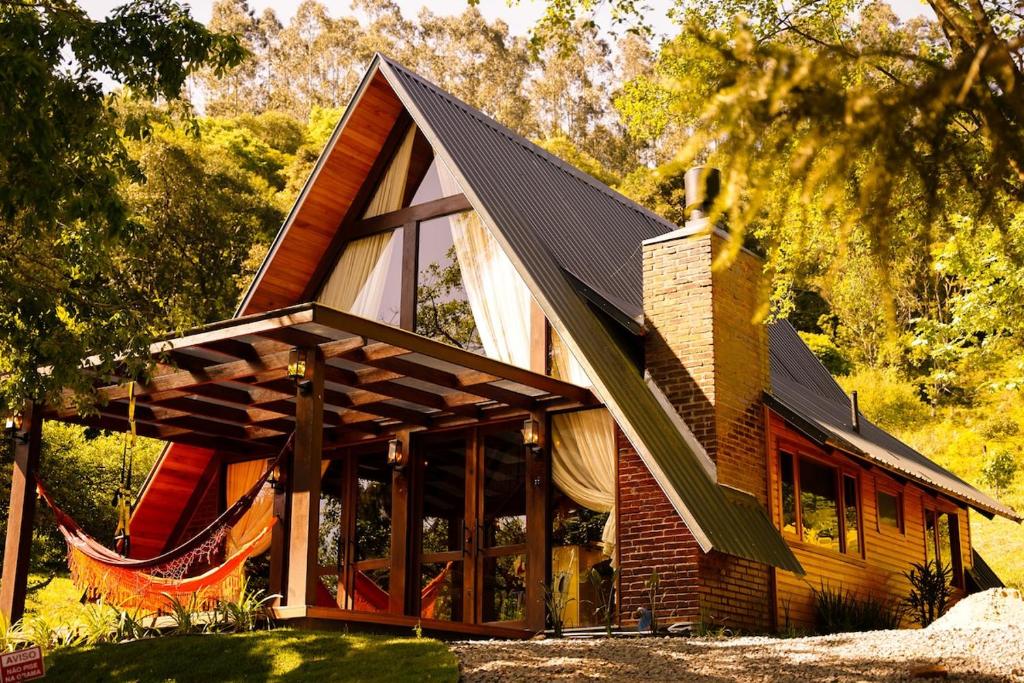 a wooden house with a gambrel roof at Relaggio Chalet Encantado - Cristo Protetor in Encantado