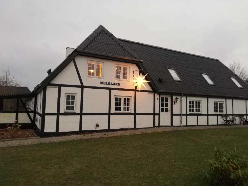 a white and black building with a star in the window at Annekset - Bjørnø in Faaborg