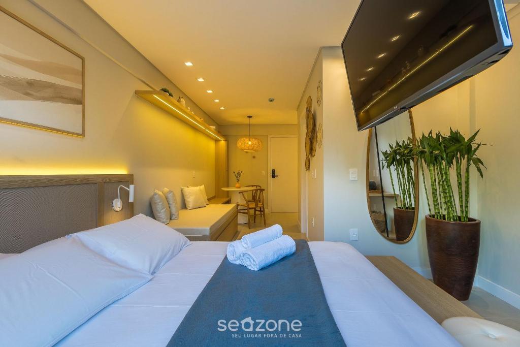 a bedroom with a large white bed in a room at Studio in center of Rosa, rooftop w/ pool RSO0031 in Imbituba