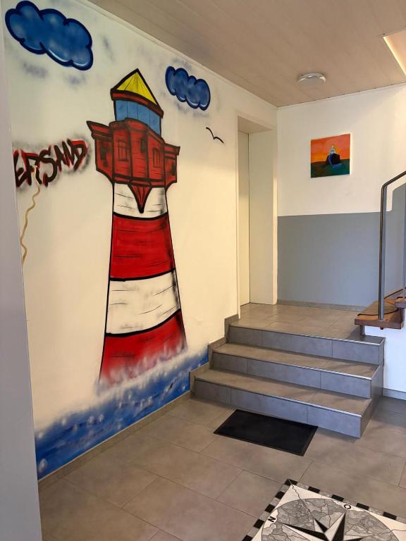 a mural of a lighthouse on a wall in a room at Monteurwohnungen Am Deich - Ideal für Langzeitaufenthalte in ruhiger Lage in Bremerhaven
