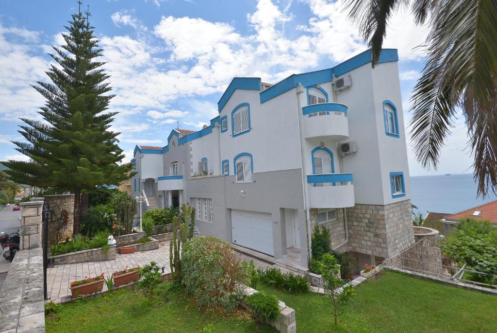 uma grande casa branca com uma palmeira em Hotel Vila Margot em Herceg Novi