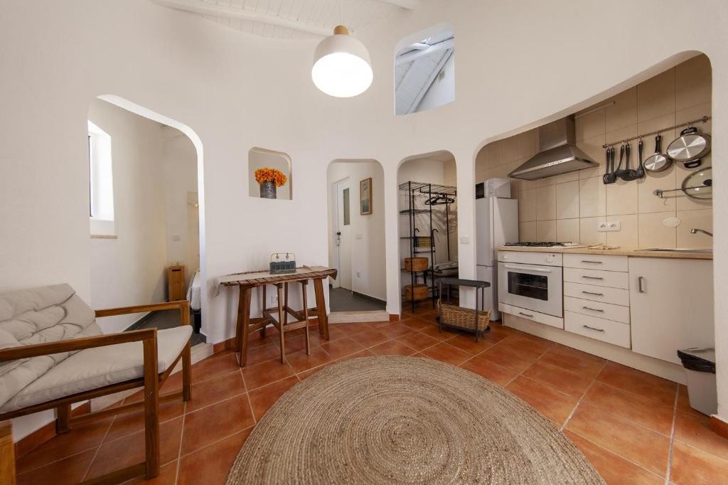 a kitchen and living room with a couch and a table at A27 - Caracol Corner Studio in Lagos in Lagos