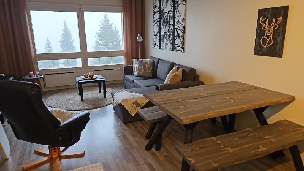 a living room with a table and a couch at Näköalahuoneisto 426 in Syöte