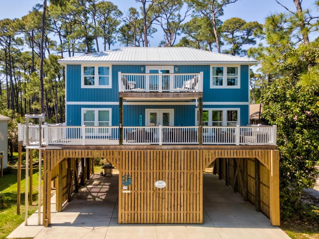 a house on a boardwalk with a blue house at Blue Haven - 1414 Oleander in Dauphin Island