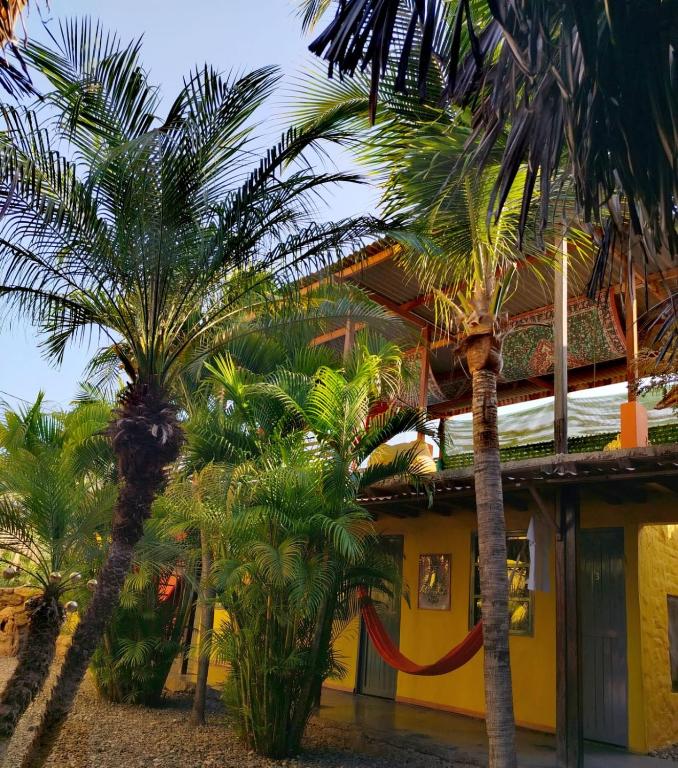 a yellow building with palm trees in front of it at Casa Naranja in Máncora