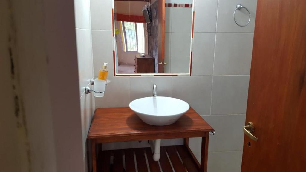 a bathroom with a white bowl sink and a mirror at Los Aromos Cabañas loft in San Marcos Sierras