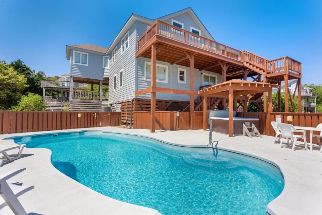 a home with a swimming pool and a house at 2058 - Blessed by the Sea Duck in Duck