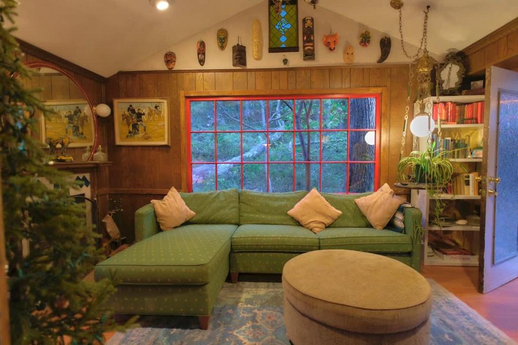 a living room with a green couch and a christmas tree at Vintage Lovers` Cabin with Jacuzzi & Lake Access in Linden
