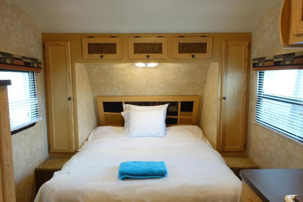 a bedroom with a bed with a blue towel on it at Best RV-Camper To Visit NYC-Hot Tub-Free Parking in Hillside