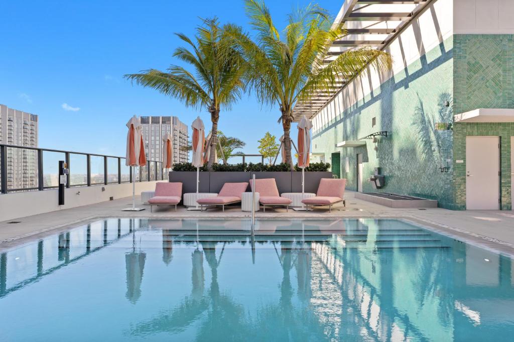 a swimming pool with pink chairs next to a building at 1Bd Top Location Downtown Miami in Miami