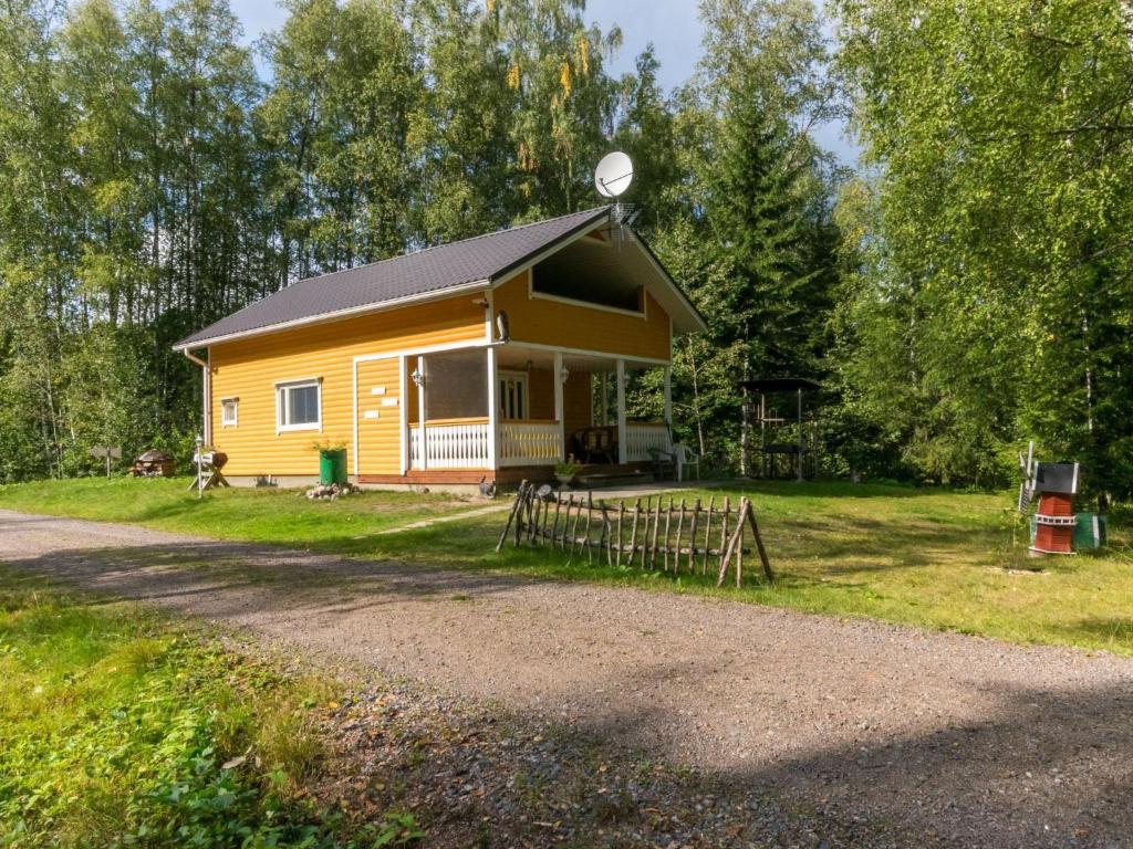 a small yellow house with a fence in the yard at Holiday Home Pöllö by Interhome in Verla