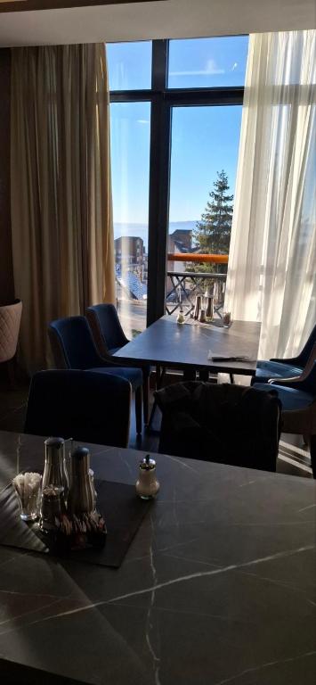 a room with a table and chairs and a large window at Yellow Hill Apartment in Cajetina