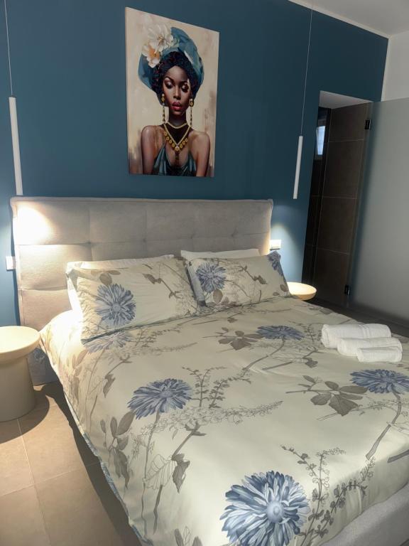 a bedroom with a bed with a painting on the wall at Luxury Rooms Soraja in Palermo