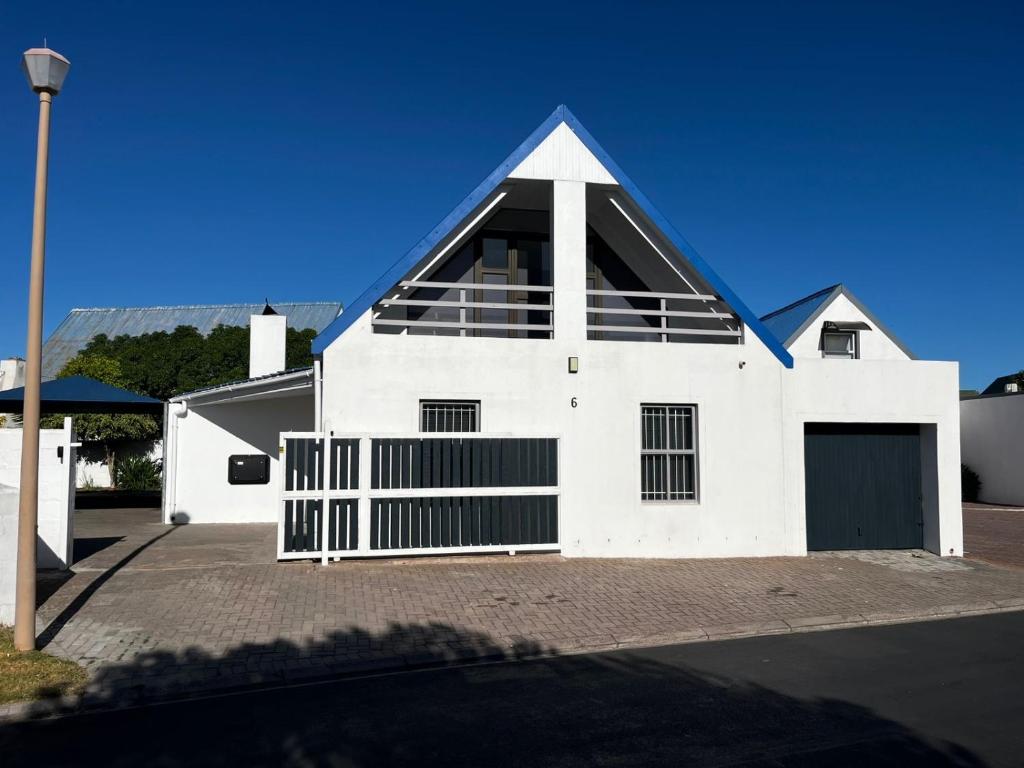 a white house with a blue roof at 6 On Santorini in Langebaan