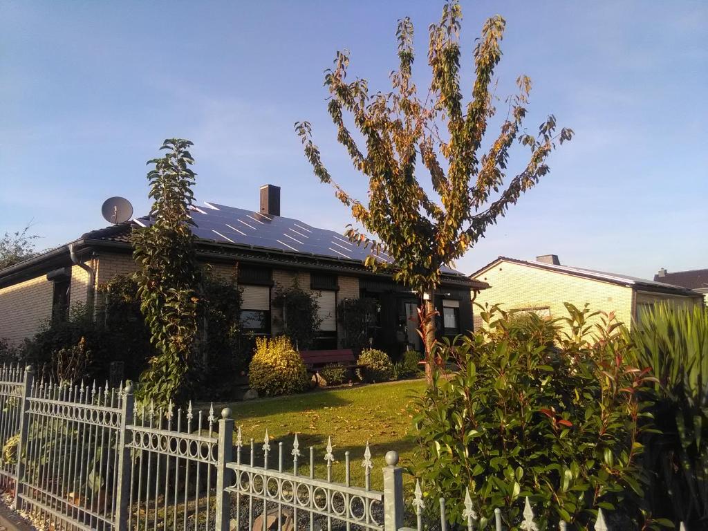 ein weißer Gartenzaun vor einem Haus in der Unterkunft Fewo Hansemann 1 in Alpen