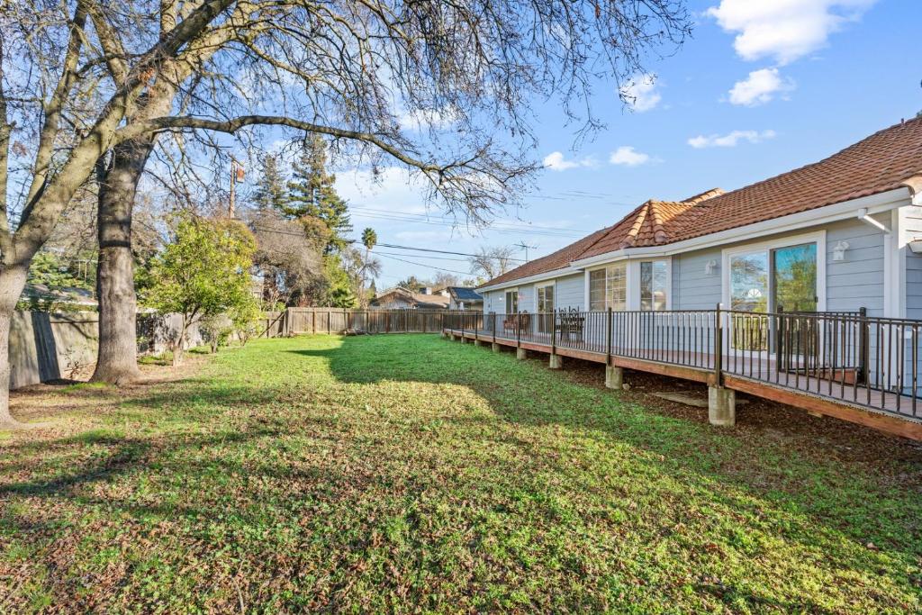 a house with a deck and a yard at Spacious 6 BR • Patio + Deck • Sleeps 13 in Sacramento