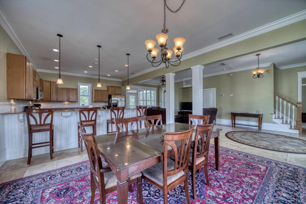 a dining room and kitchen with a table and chairs at Purple Parrot - 200 Lenora Ct in Dauphin Island