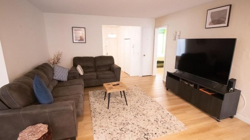 a living room with a couch and a flat screen tv at 3 cozy bedrooms 2 bathrooms in Winnipeg