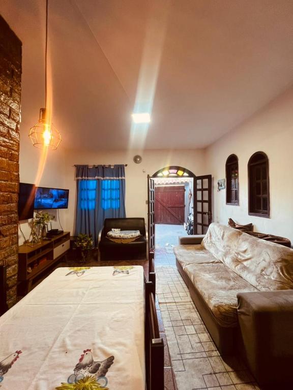 a living room with a bed and a couch at Lar Doce Estadia in São Pedro da Aldeia