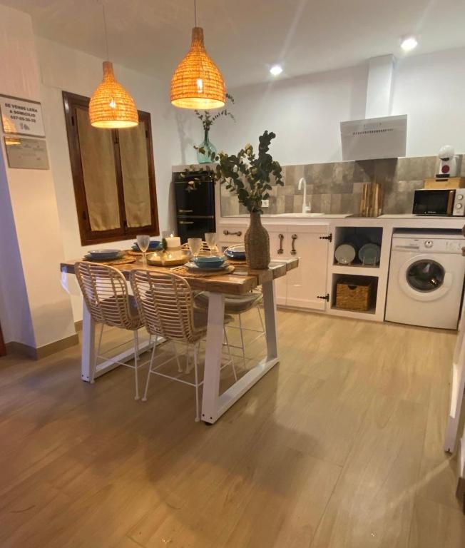 a kitchen with a table and chairs and a kitchen with at Los Llanos del Campo in Grazalema