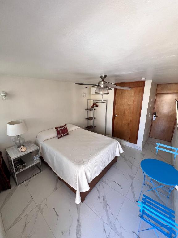 a bedroom with a bed and a ceiling fan at Hosteleria Casa Margarita in Mazatlán