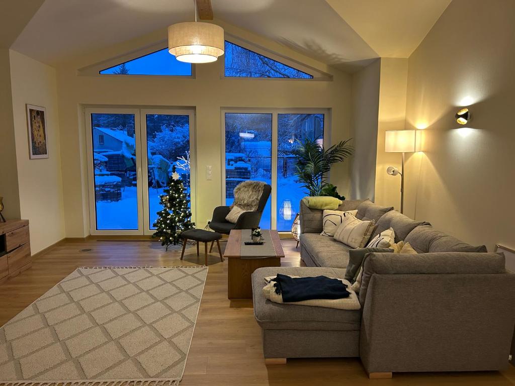 a living room with a couch and a christmas tree at Ferienhaus Senzig Waldesruh in Königs Wusterhausen